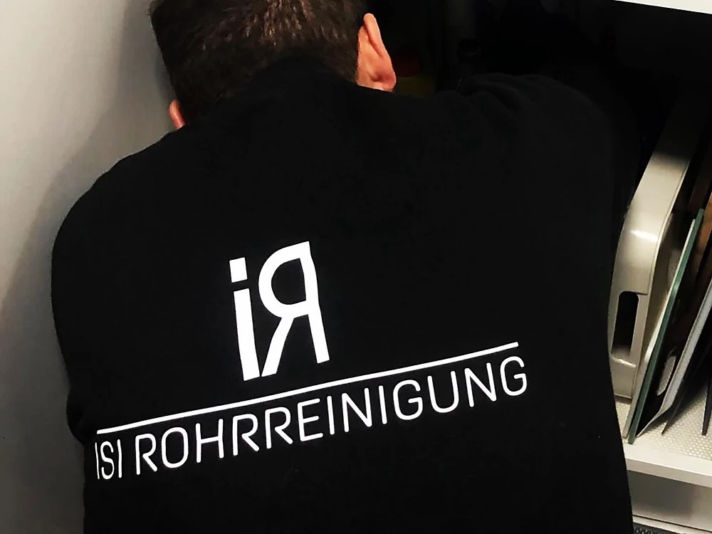 Mitarbeiter von ISI Rohrreinigung bei der Arbeit unter einem Küchenschrank